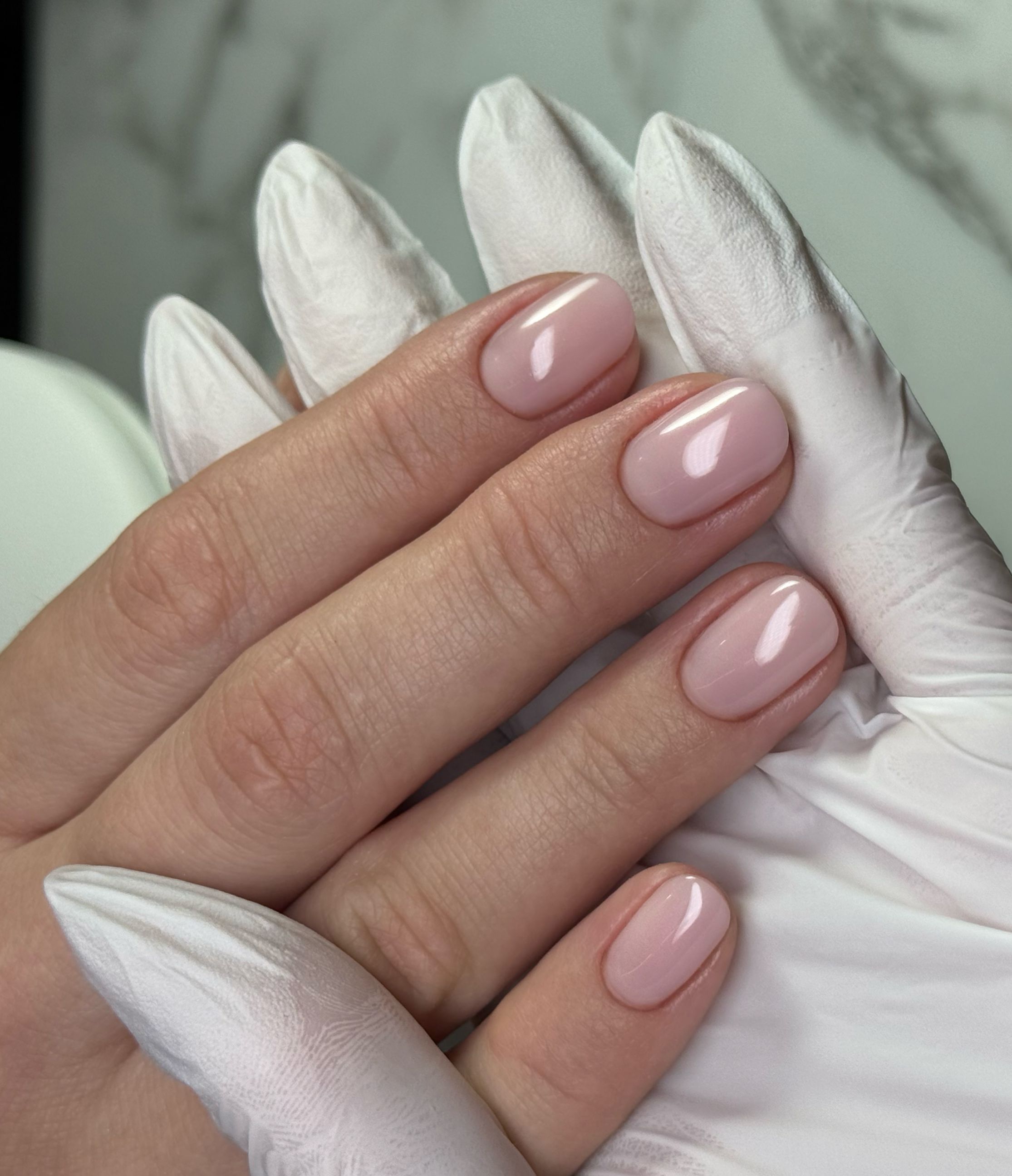 Manicure hybrydowy z mleczną bazą z w kształcie krótki owal zrobiony w ramach kursu podstawowego Mani Start