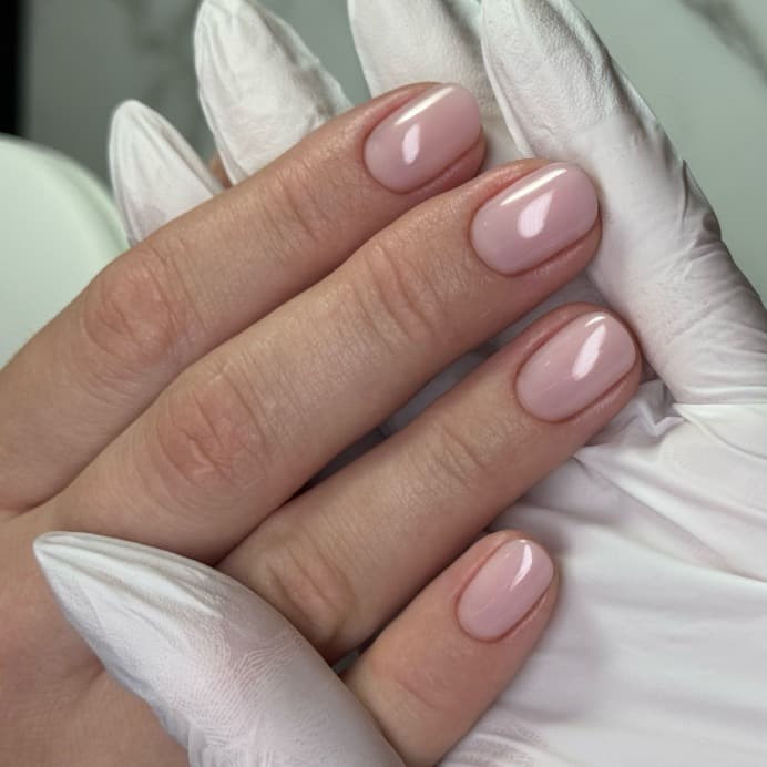 Manicure hybrydowy z mleczną bazą z w kształcie krótki owal zrobiony w ramach kursu podstawowego Mani Start